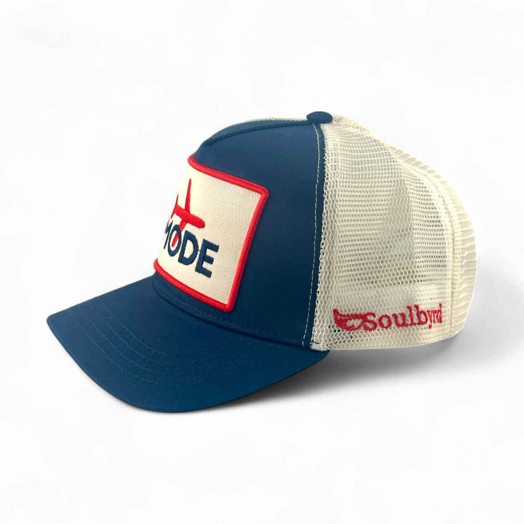 Soulbyrd Navy Trucker Hat side view showing red brand embroidery on cream mesh