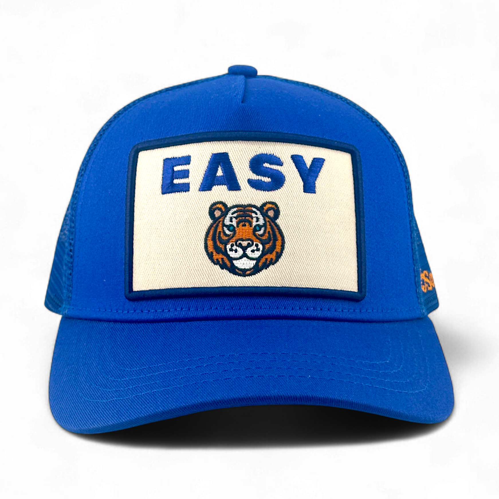 Front view of blue cotton twill Easy Tiger trucker hat featuring beige patch and orange tiger embroidery