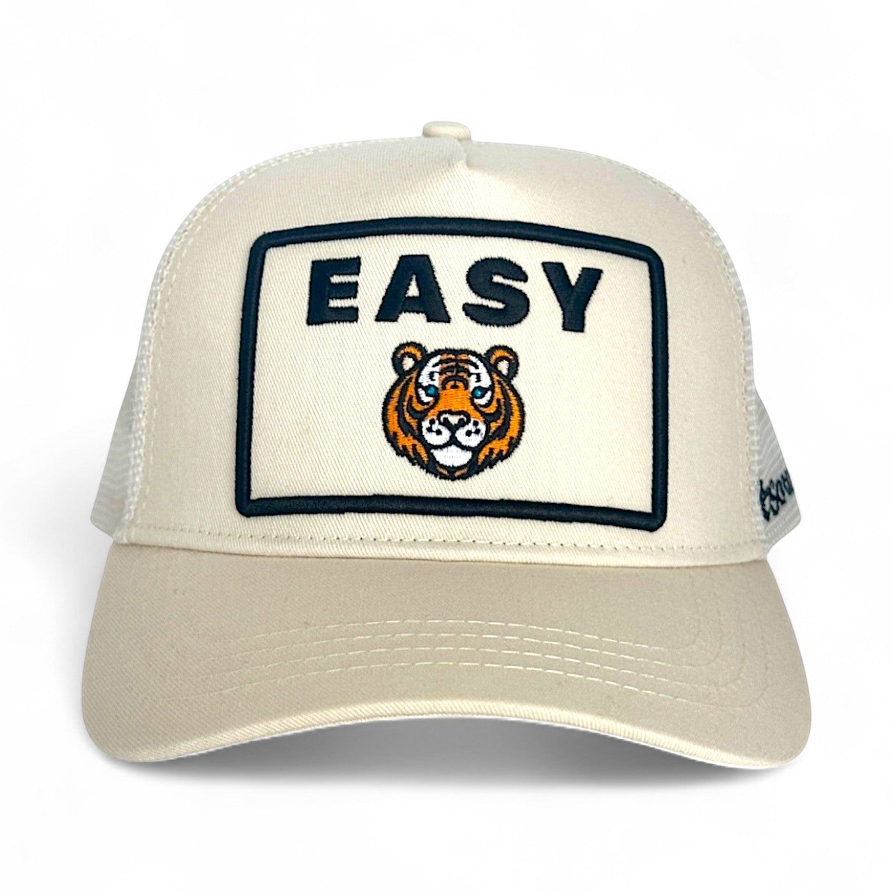 Cream Easy Tiger trucker hat front view with embroidered tiger head patch and adjustable snap back