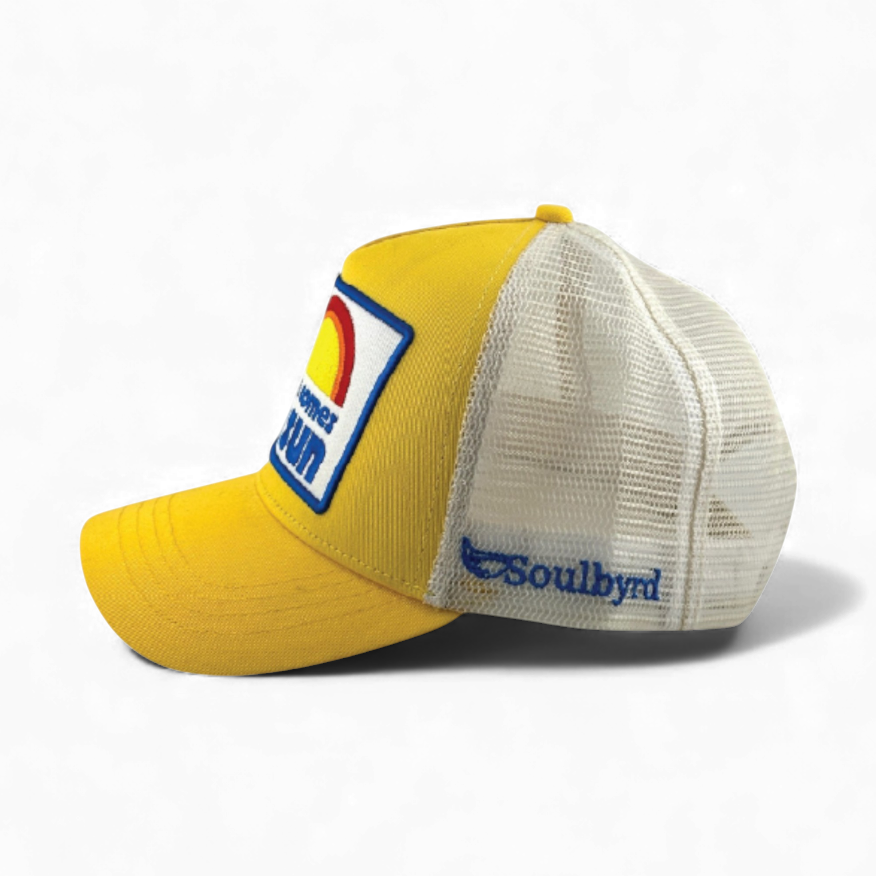 Side view of yellow cotton twill trucker hat showing Soulbyrd logo on white mesh back