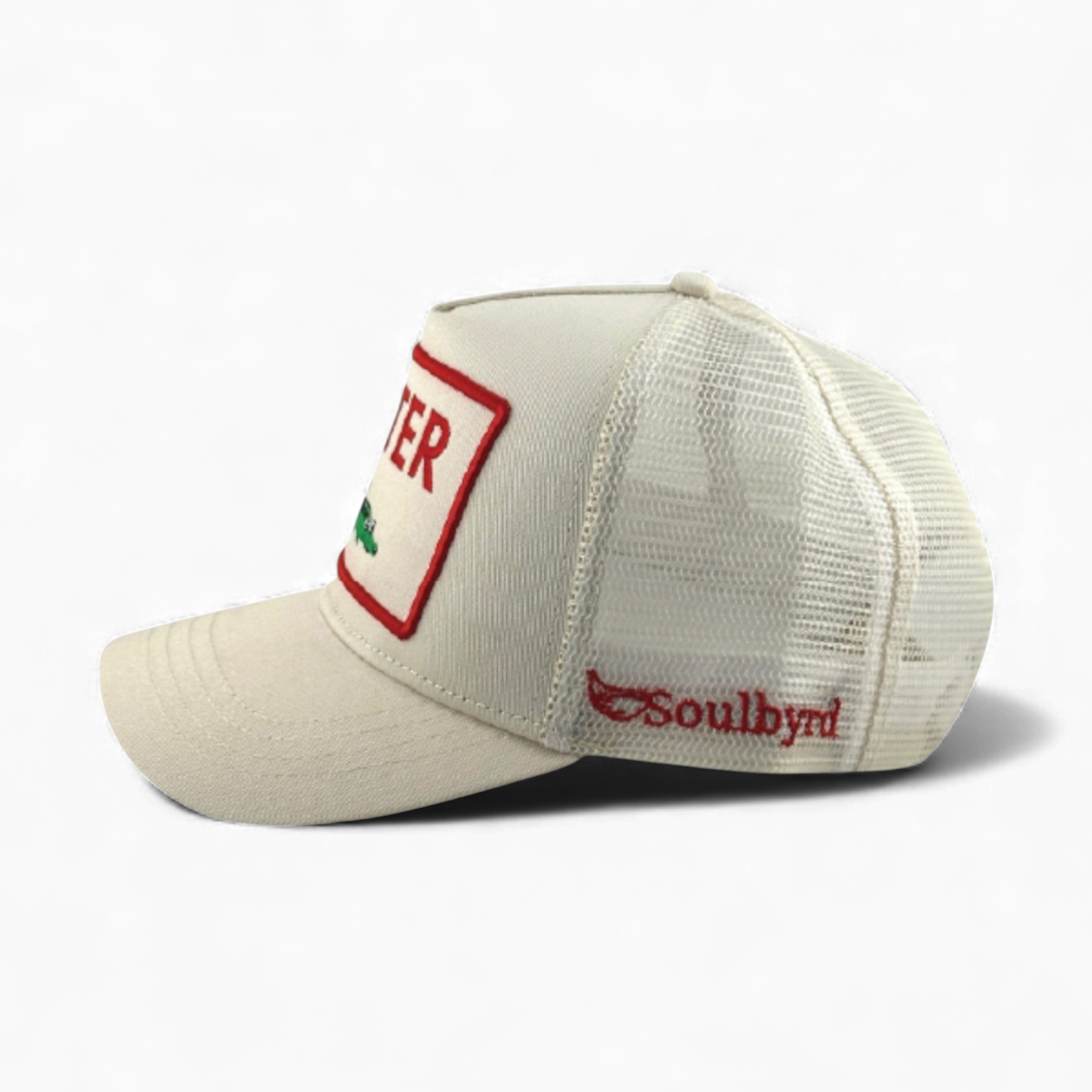 Ivory Soulbyrd trucker hat side view with red bordered patch and green crocodile graphic