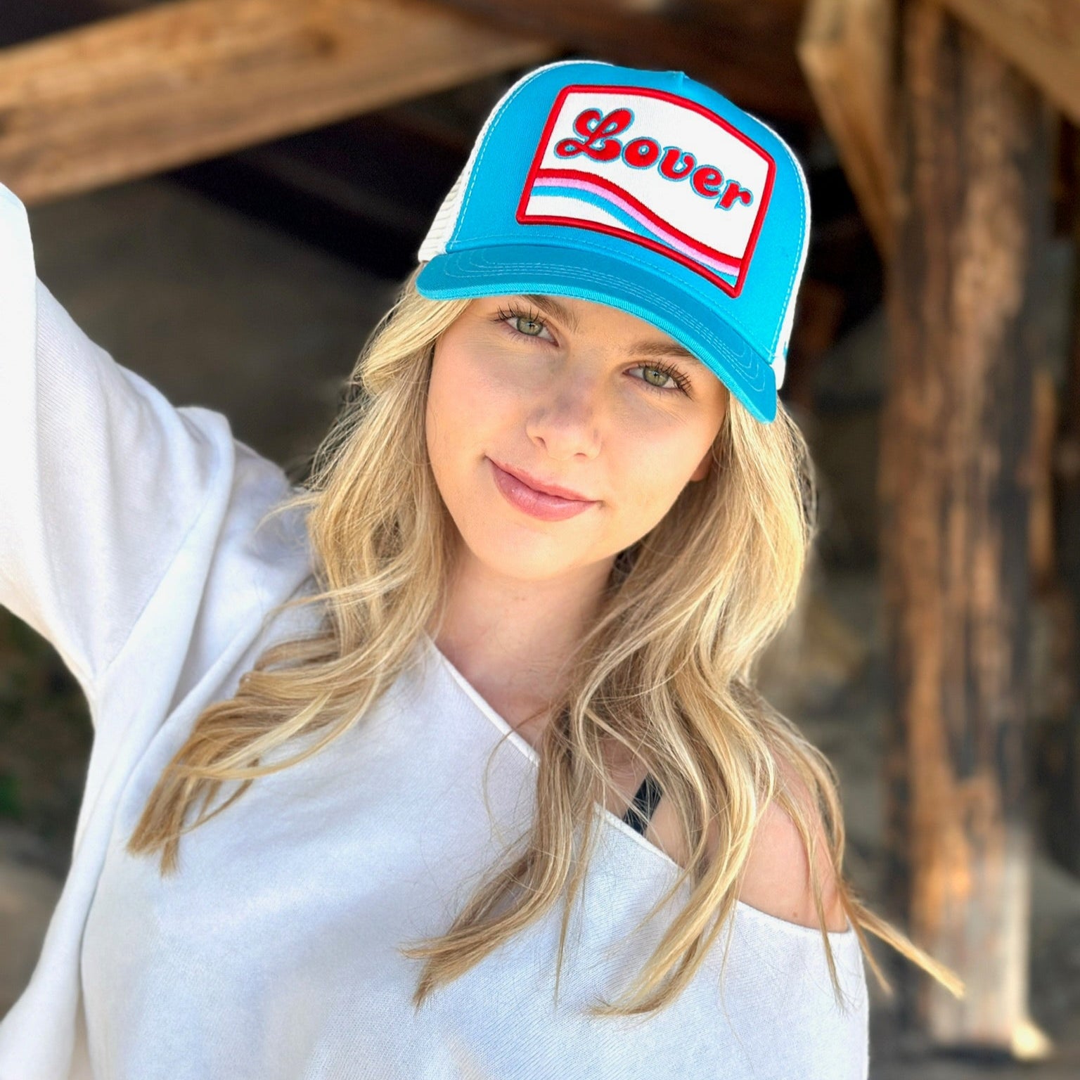 Woman wearing turquoise Soulbyrd Lover trucker hat outdoor style
