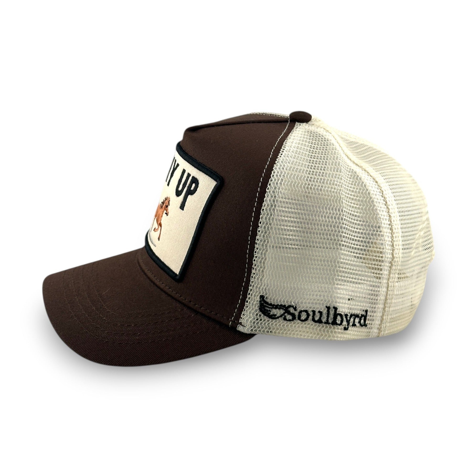 Side view of brown Soulbyrd trucker hat showing cream mesh back and embroidered brand logo