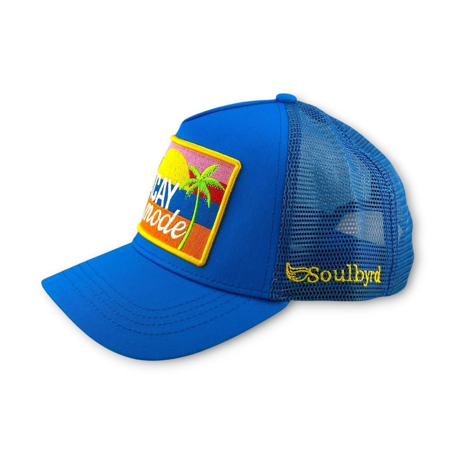 Blue Soulbyrd trucker hat side view with embroidered sunset and palm tree patch