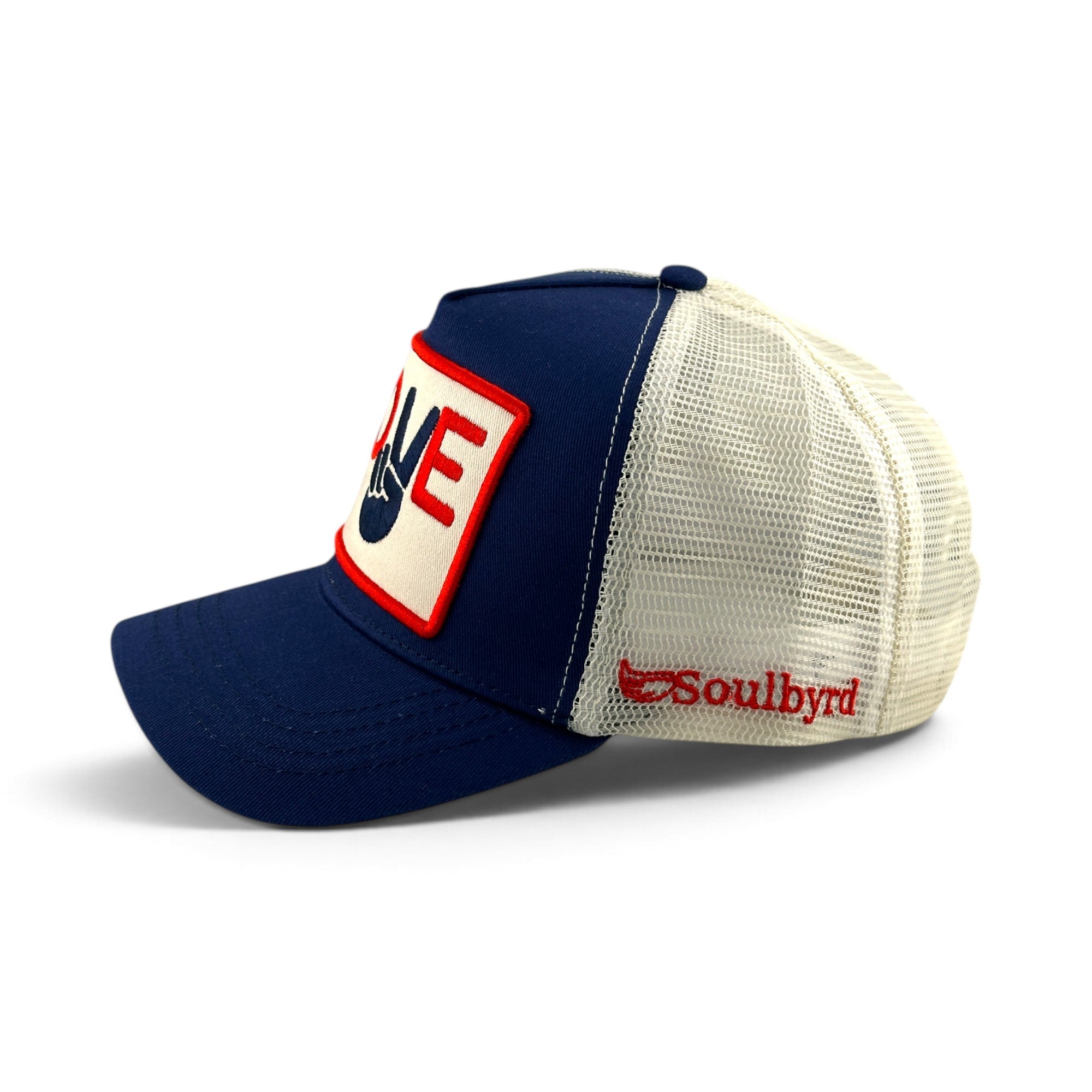 Soulbyrd Wholesale navy and white trucker hat featuring a Love and Peace patch and side embroidery