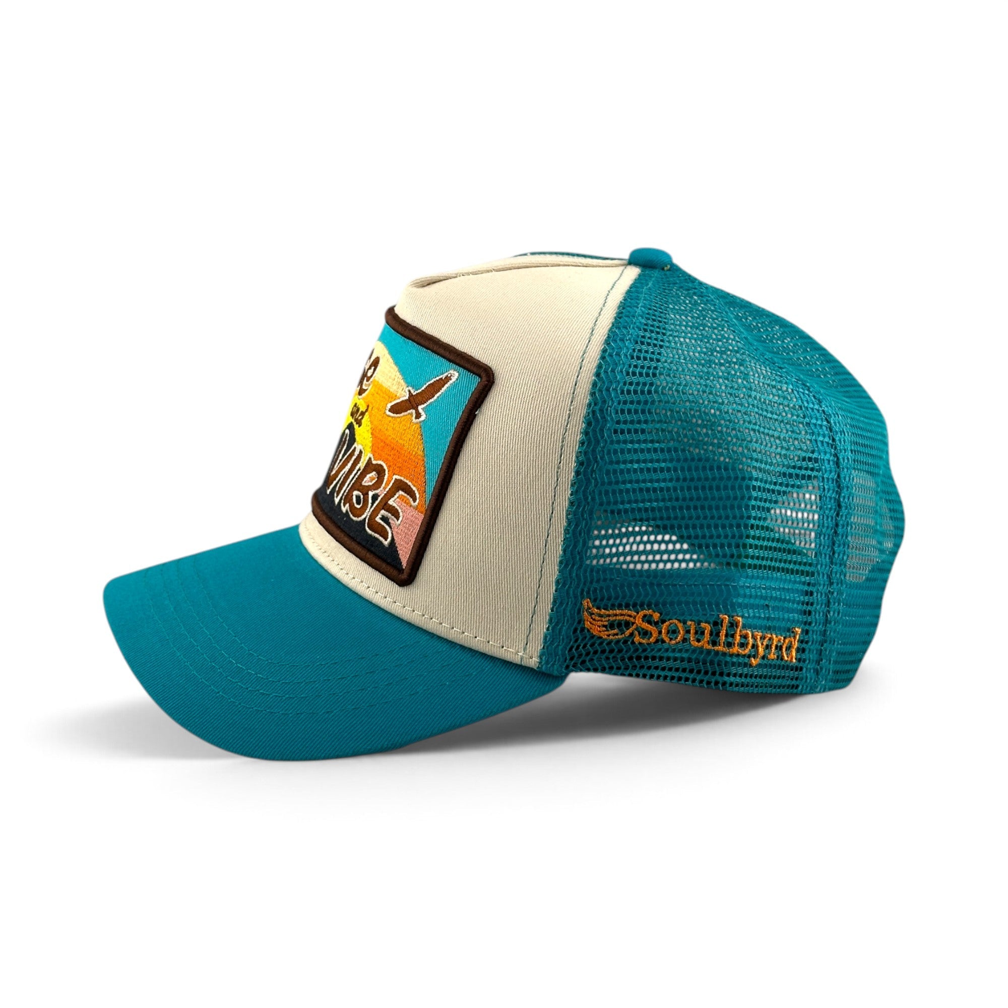 Soulbyrd Wholesale turquoise and cream 5-panel trucker hat with Rise & Vibe patch and mesh back